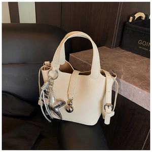 Detalle del bolso de cubo blanco roto textura lichi con colgante de estrella de plata