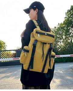 Outdoor view of bright yellow large travel backpack with waterproof nylon texture and side pocket