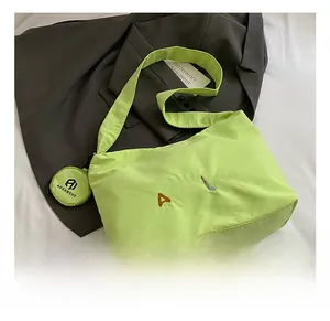 Vue détaillée du sac fourre-tout vert fluo plissé avec mini pochette assortie et broderie