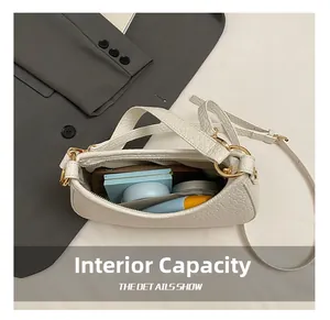 Macro shot showing internal capacity of white crocodile pattern shoulder bag for cosmetics