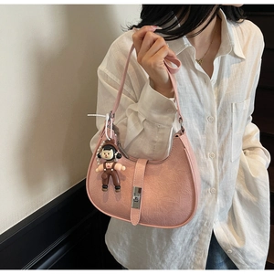 Detailed view of a pink pleated Hobo bag featuring a silver buckle and cute doll charm