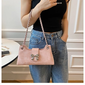 Détail du sac à bandoulière rose avec un nœud en métal argenté et une chaîne tressée