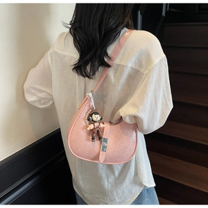 Pink crescent shoulder bag in textured leather with silver lock and a cute doll charm