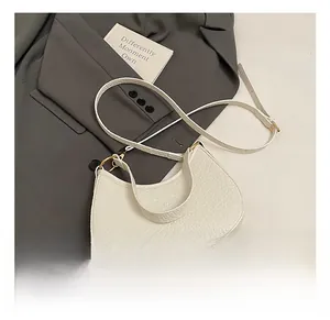 Detailed macro view of white crocodile embossed leather handbag with gold metal clasp