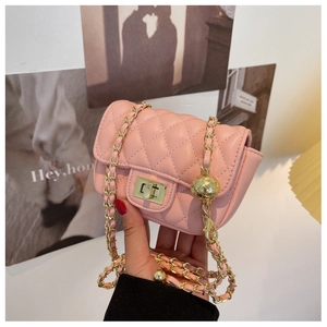 Detail of pink quilted mini crossbody bag featuring golden chain and ball ornament
