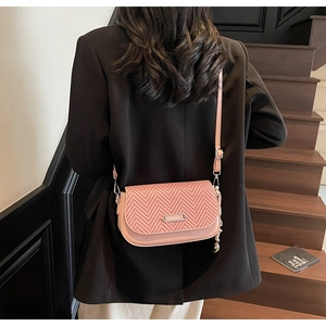 Détail du sac bandoulière rose avec rabat tissé et plaque métallique FASHION