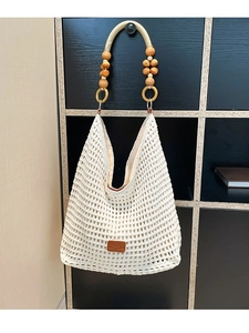 Beige hollow knit tote bag with floral wooden bead handles and leather patch accent