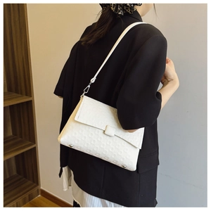 Detail of white embossed square texture on stylish minimalist crossbody shoulder bag
