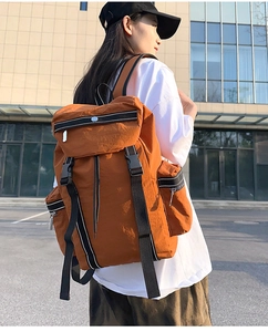 Close-up of caramel nylon outdoor backpack with adjustable straps in a city street scene