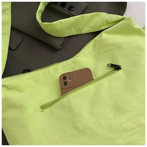 Détail du cabas en nylon vert néon plissé avec une poche zippée pratique pour le téléphone