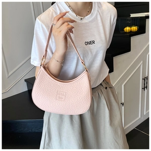 Detail of light pink half-moon shoulder bag showing pebble leather texture and logo