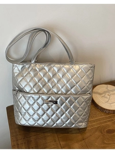 Silver quilted tote bag with metallic finish and long shoulder straps for versatile daily use