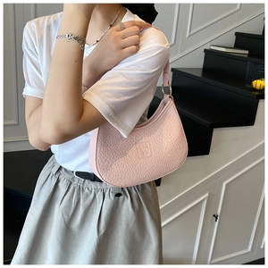 Close-up of pink embossed leather underarm bag with gold rings and brand logo details