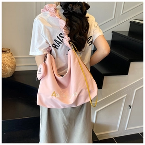 Détail du sac cabas rose en nylon avec bandoulière à volants et petit porte-monnaie
