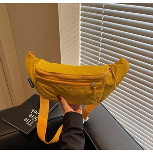 Detail of a vibrant yellow nylon fanny pack showing a durable zipper and adjustable strap