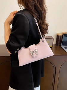 Sac baguette rose avec nœud métallique argenté et bandoulière en chaîne de cuir