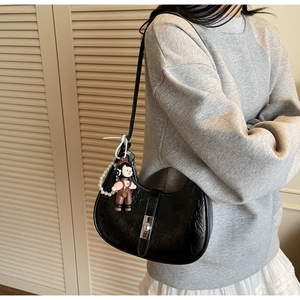 Detail of black crescent handbag with crinkle leather texture and silver lock closure