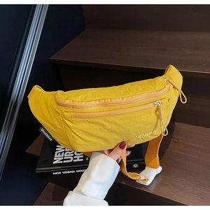 Detail view of bright yellow waterproof nylon waist bag with double zipper and buckle strap