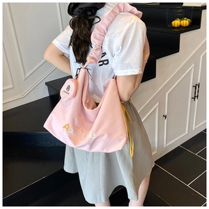 Détail du sac fourre-tout rose clair avec bandoulière plissée et mini porte-monnaie