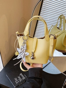 Bolso cubo amarillo con textura de lichi y colgantes de estrella y perro globo