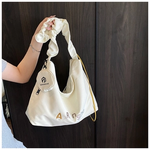 Détail du sac cabas plissé blanc crème avec petit porte-monnaie rond et logo brodé