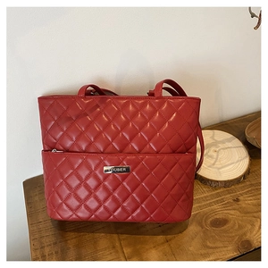 Detailed close-up of red quilted rhombic pattern tote bag with metal brand name plate