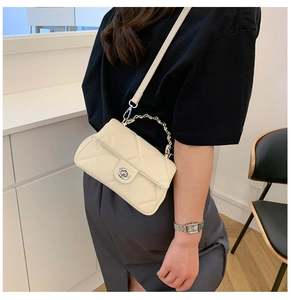 Detail of off-white quilted shoulder bag showing the luxury texture and silver chain strap