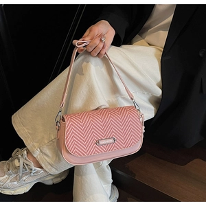 Détail du sac bandoulière en tweed rose avec plaque Fashion porté par un mannequin