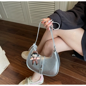 Detail of silver metallic hobo bag with crushed leather texture and cute charm