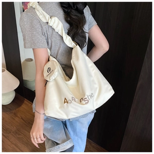 Détail du sac cabas crème avec bandoulière plissée et mini porte-monnaie amovible