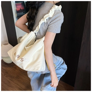 Gros plan du sac cabas blanc cassé avec bandoulière plissée et broderie Air She