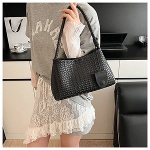 Close-up of black woven leather tote bag featuring detailed Intrecciato craftsmanship