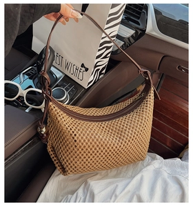 Détail du sac hobo tissé à la main beige avec poignée en similicuir brun et fermeture éclair