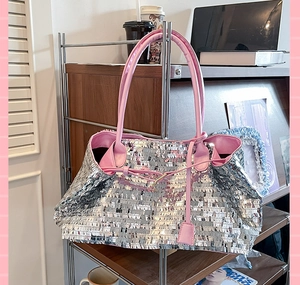 Detail of silver sequin tote bag with pink faux leather trim and metallic finish