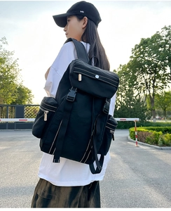 Outdoor shot of a black waterproof nylon travel backpack with multiple functional pockets