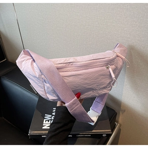 Detail of lavender nylon waist bag with double zippers and plastic buckle strap