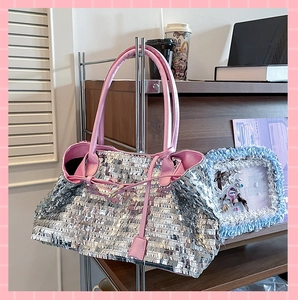 Detail of silver rectangular sequins on a tote bag with pink leather handle accents