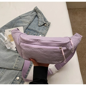 Close-up of purple nylon waist bag featuring dual zippers and white buckle detail