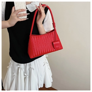 Close-up of red woven leather tote bag texture and matching half-moon pouch charm