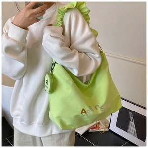 Détail du cabas plissé vert fluo avec porte-monnaie rond et impression du logo