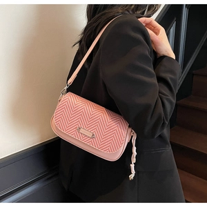 Détail du sac à bandoulière en similicuir rose avec tissage chevrons et plaque métal