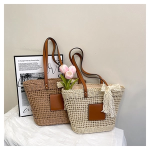 Detailed close-up of woven straw tote bags with leather handles and lace bow accent
