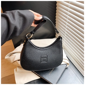 Detail of black pebbled leather crescent bag with gold ring hardware and SV.C logo