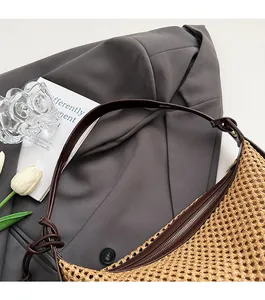 Détail du sac en paille tressée avec bandoulière en cuir marron et nœud élégant