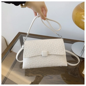 Detail view of cream white PU leather shoulder bag with textured embossed square patterns