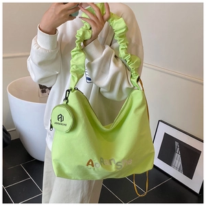 Détail du sac cabas plissé vert néon avec mini pochette ronde assortie de luxe