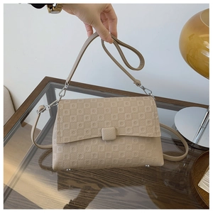 Detail of beige PU leather shoulder bag with geometric embossing and silver hardware