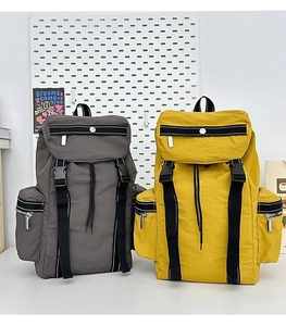 Detail view of large travel backpacks in yellow and grey showing waterproof nylon fabric