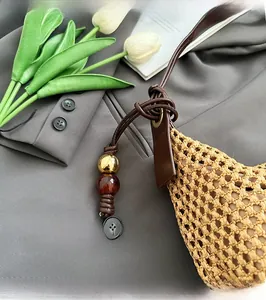 Détail de la texture en paille tressée et bandoulière en cuir avec perles décoratives
