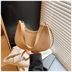 Detail of light beige crescent shoulder bag with crocodile pattern and S.Y.B BAG logo